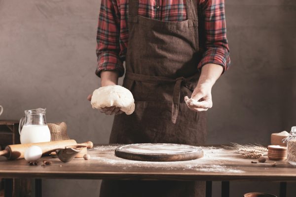 Baker man making dough and bakery ingredients for homemade bread cooking on table. Bakery concept